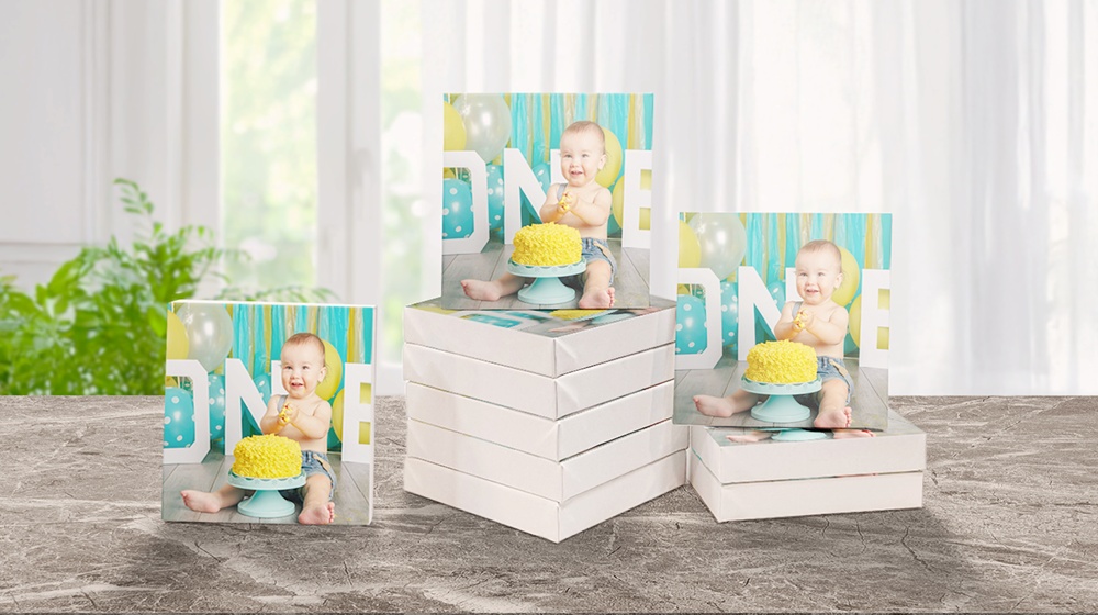 ten small canvas prints with image of first birthday printed on them displayed on a table