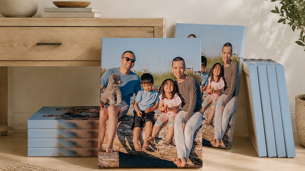 Family beach photo canvas prints displayed beside stacked canvases.