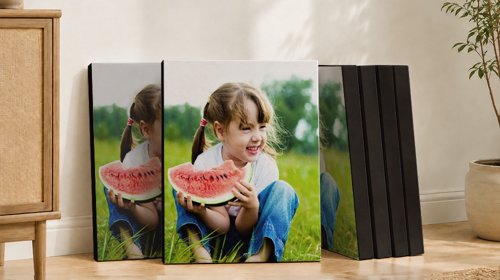 Canvas prints of a smiling child holding a watermelon slice.