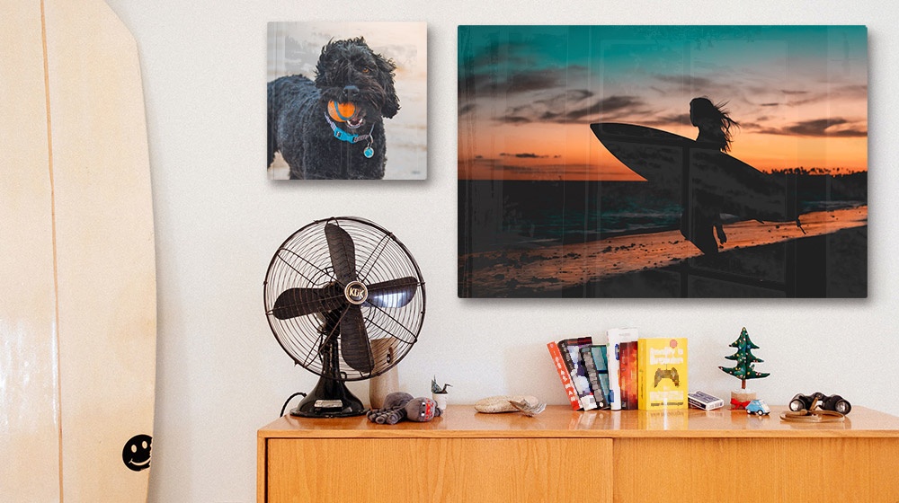 two acrylic photo prints of a surfer and dog over a sideboard