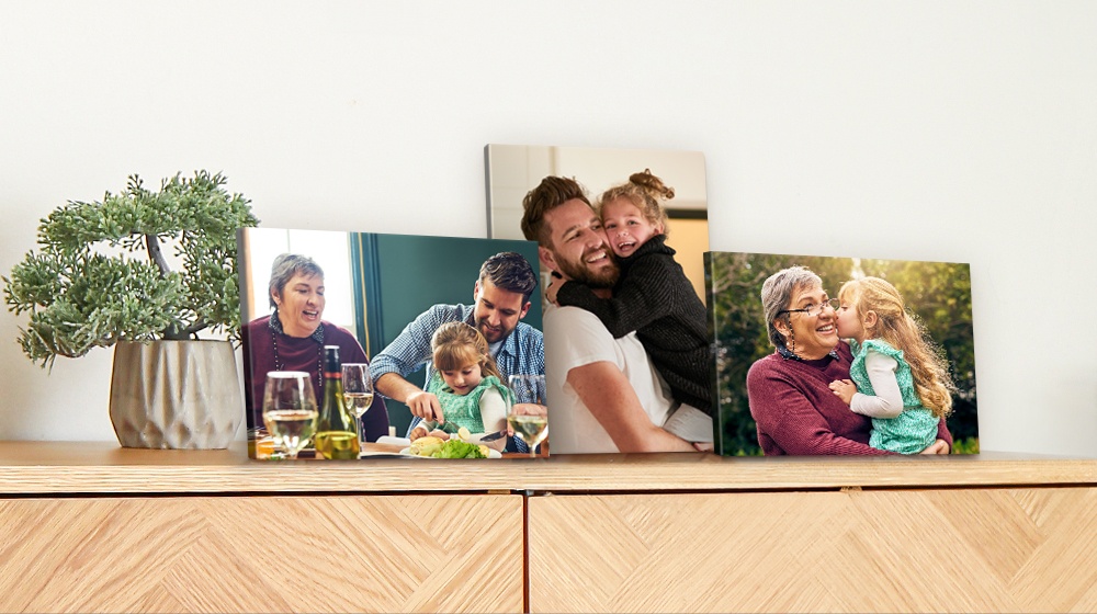 Three 5x7 desktop canvas prints sitting on a desk depicting family photos