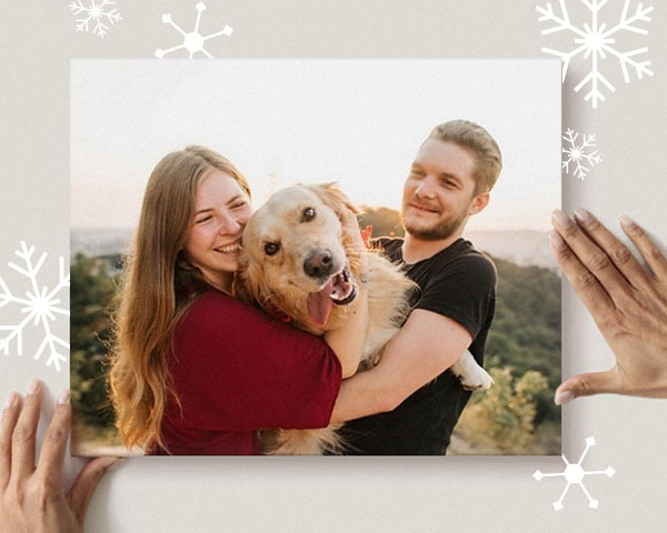 A sweet couple holding their goofy dog
