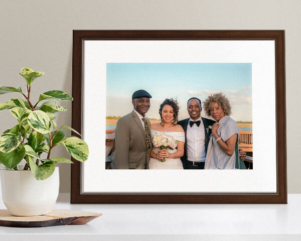 framed print of a family at a wedding next to potted plant