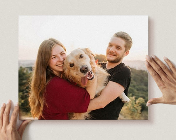 A sweet couple holding their goofy dog