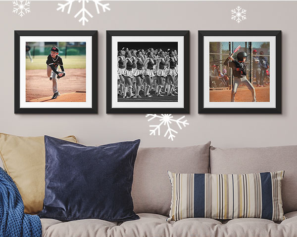 three framed sports prints hung in a row over the couch