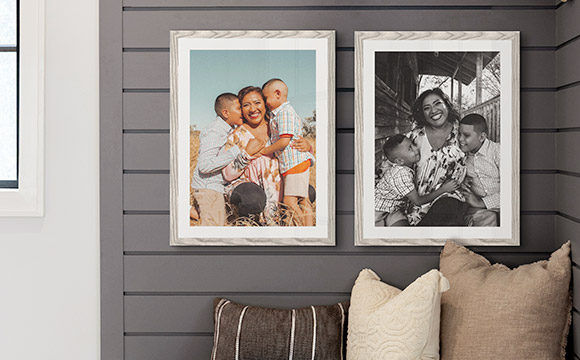 Two grayish white framed prints hanging in an entryway