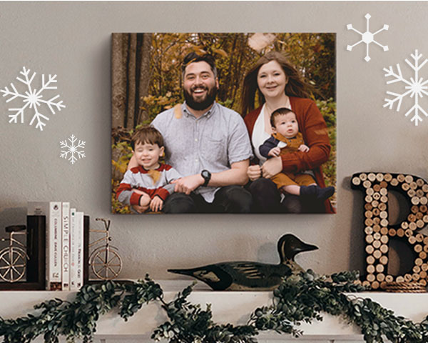 mom, dad, and child outside in winter sweaters and hats pictured on a canvas hung above a mantle