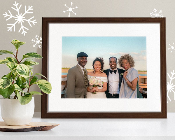framed print of a family at a wedding next to potted plant
